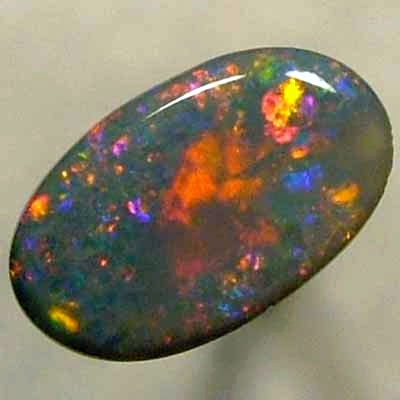 SOLID BLACK OPAL Large central rolling flash of bright crimson surrounded by sparkles of the same colour.