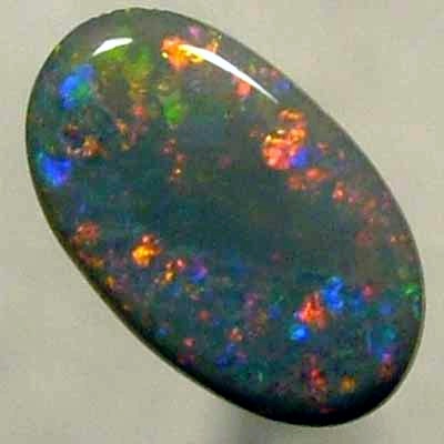 SOLID BLACK OPAL Large central rolling flash of bright crimson surrounded by sparkles of the same colour.