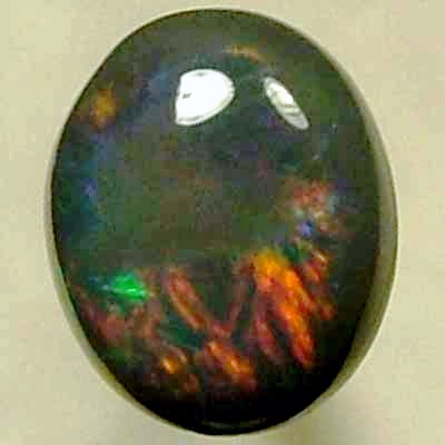 SOLID BLACK OPAL Rolling flashes of bright reds contrast with peacock blue