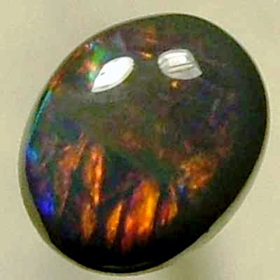 SOLID BLACK OPAL Rolling flashes of bright reds contrast with peacock blue