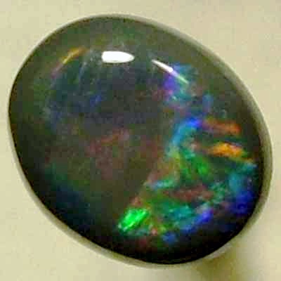 SOLID BLACK OPAL Rolling flashes of bright reds contrast with peacock blue